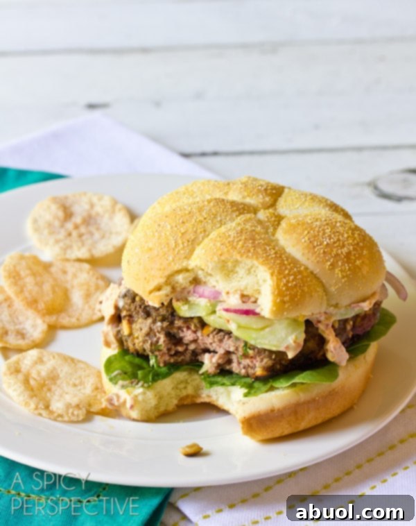 A close-up shot of an easy Mediterranean burger, featuring the succulent patty, fresh toppings, and vibrant colors, ready to be enjoyed. Ideal for sharing with #burgers #hamburgers #summer.