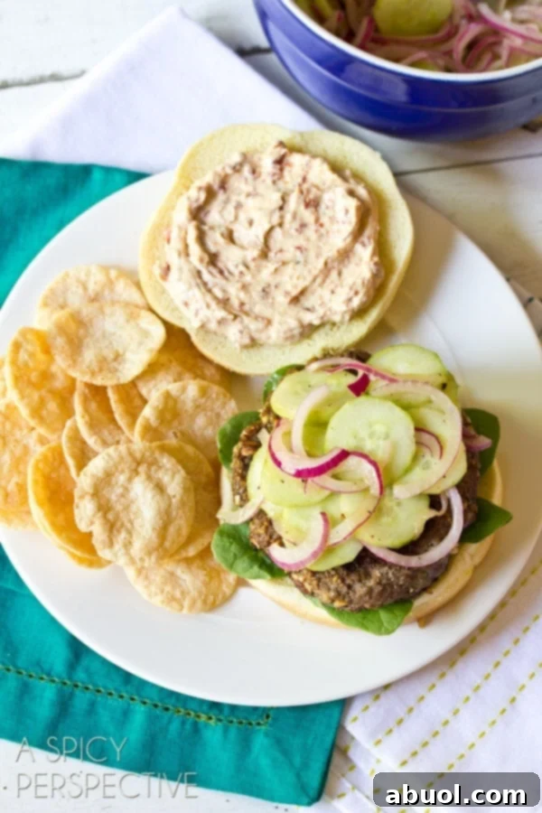 An overhead shot of a plated Mediterranean burger, impeccably presented with a side of chips, inviting diners to indulge.