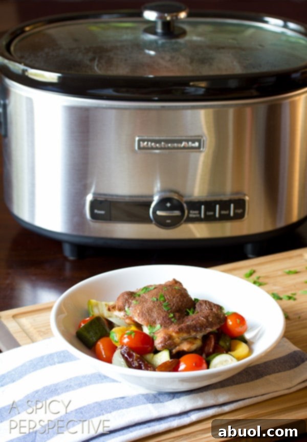 Close-up of cooked Slow Cooker Moroccan Chicken with vegetables, fruits, and almonds, ready to serve