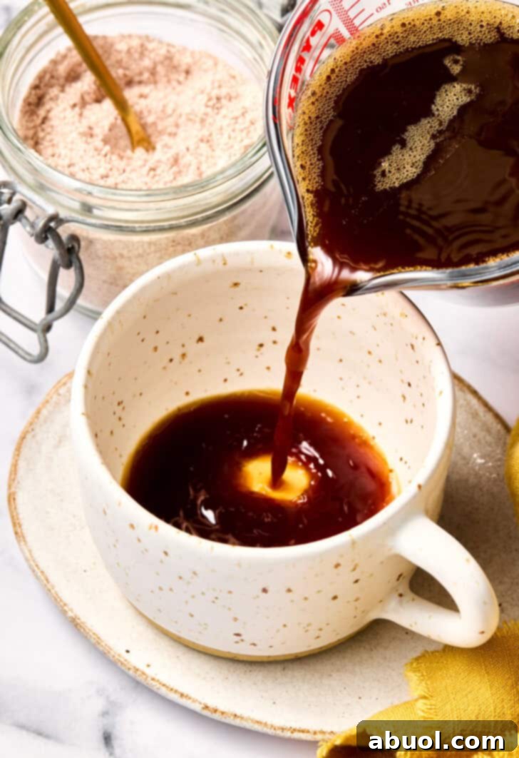 Pouring freshly brewed coffee into a large mug, ready for the mocha mix