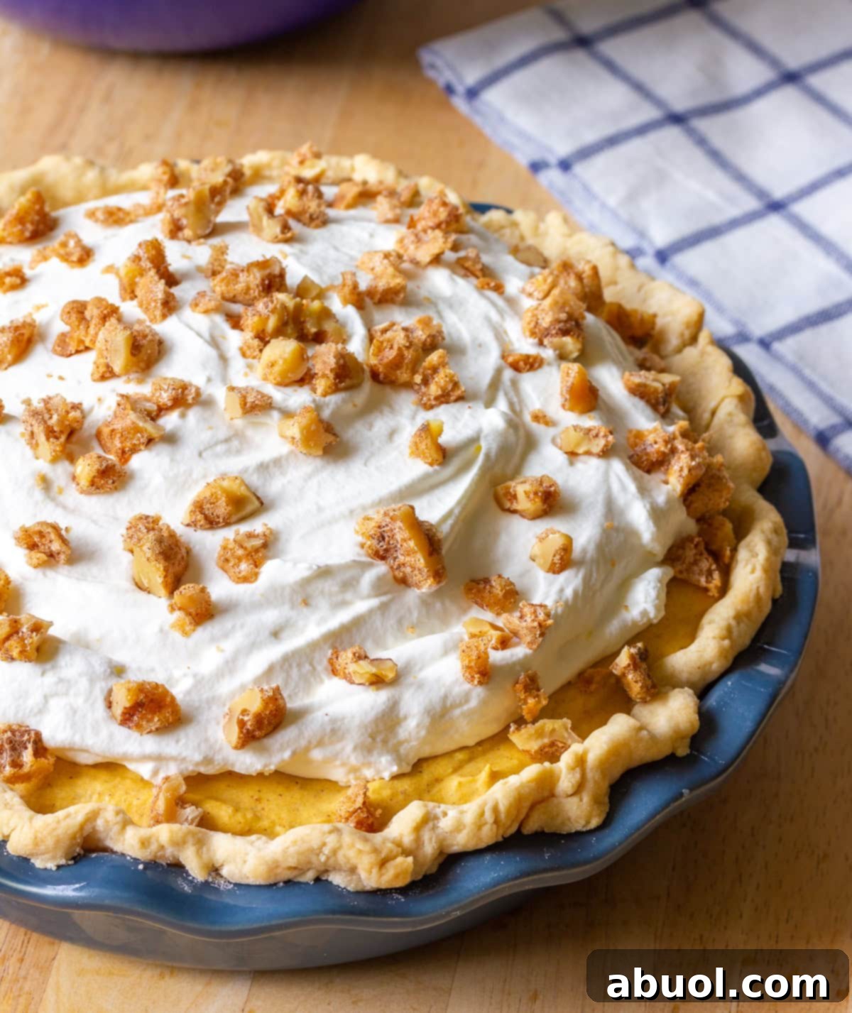 Fall-Dessert A festive pumpkin dessert featuring a golden pie crust, a rich pumpkin filling, and a generous dollop of whipped cream, beautifully garnished for a fall celebration.