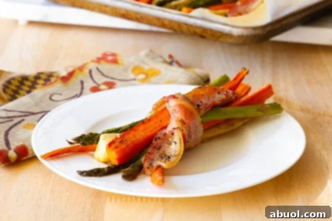 Slices of roasted vegetables wrapped in bacon on a white plate. 