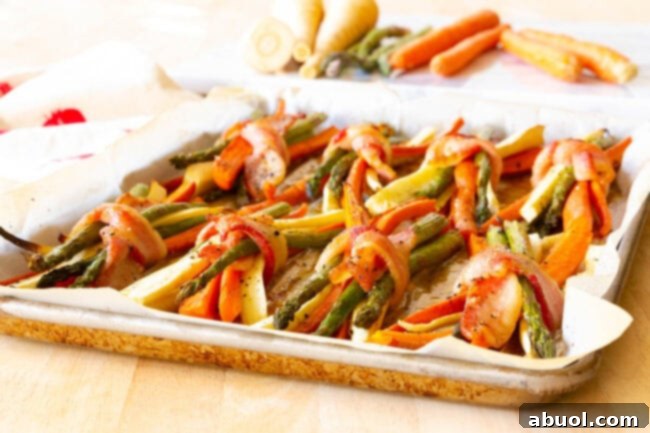 Bacon wrapped veggies on a baking dish. 