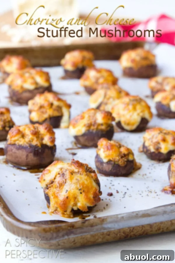 Close-up of baked Chorizo and Cheese Stuffed Mushrooms on a baking sheet, showcasing their golden crust and savory filling.