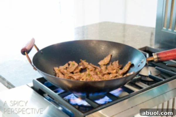 Korean beef bulgogi sizzling and cooking to perfection in a black wok.