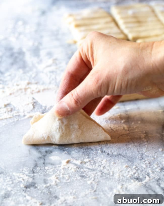 Hand pinching together dumpling.