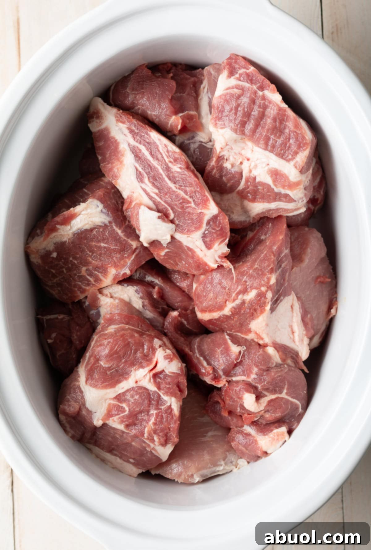 Chunks of raw pork butt roast ready for slow cooking.