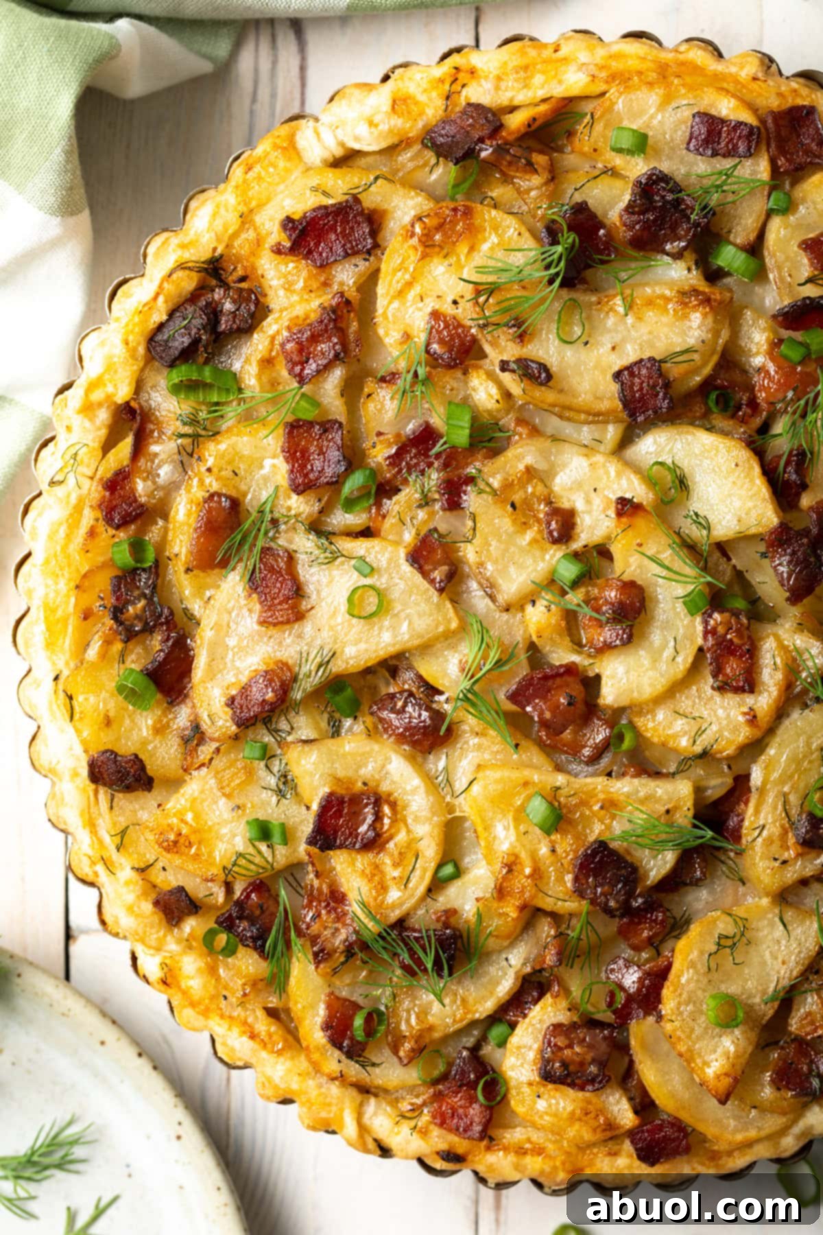 Overhead shot of Irish potato pie in a tart tin, showing crispy crust and layered potatoes, onions, and bacon.