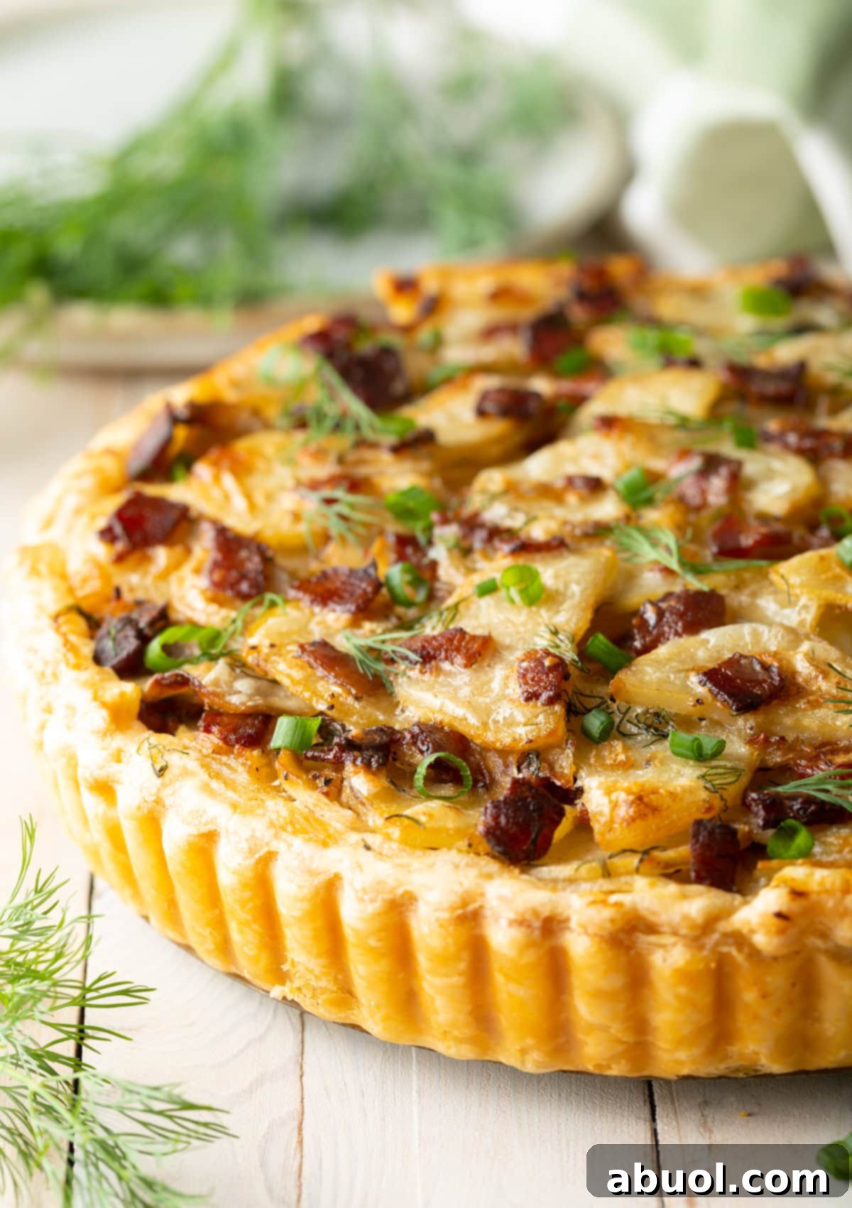 Side view of a rustic potato tart, showcasing its golden crust and delicious layers.