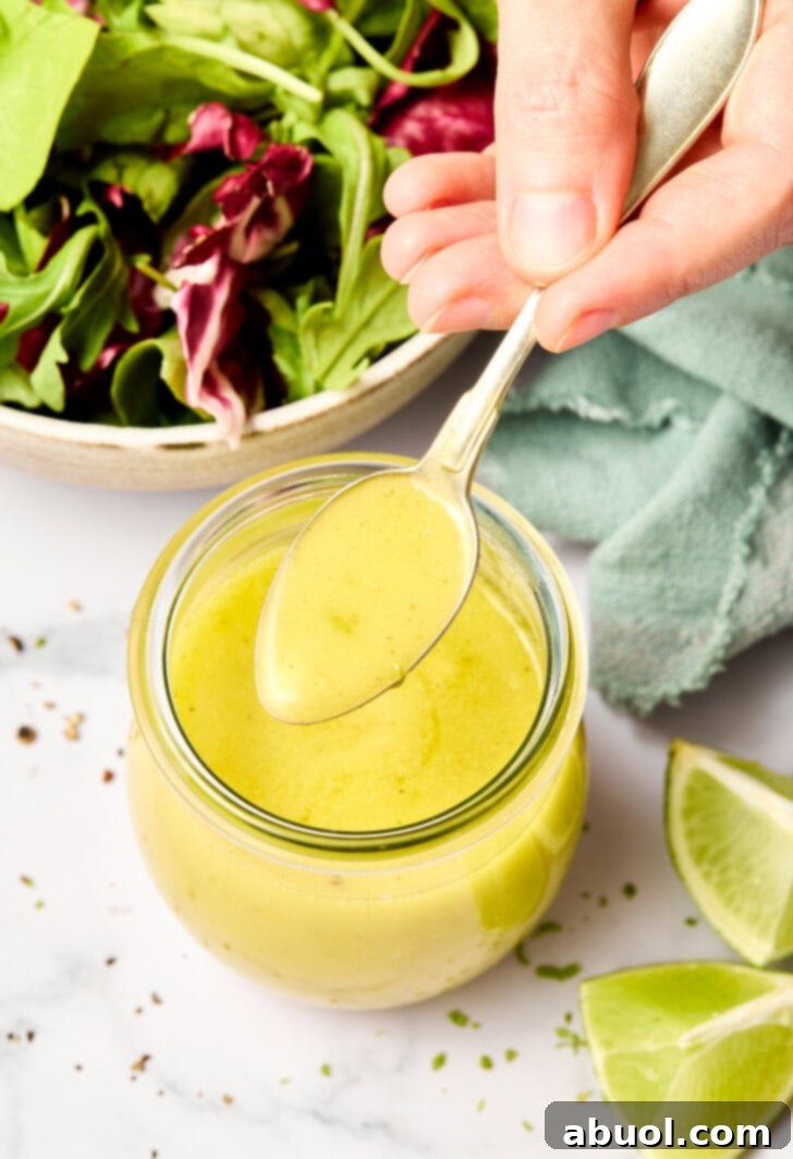 Lime Vinaigrette Recipe with Garlic in jar - spoon lifting sauce