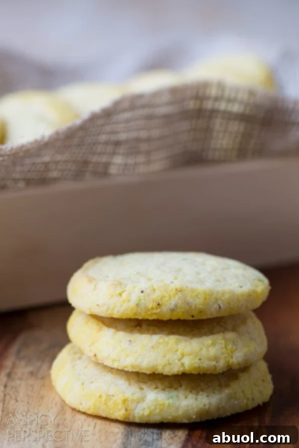 Beautifully arranged soft Cornmeal Sugar Cookies on a counter with a baking dish in the background.