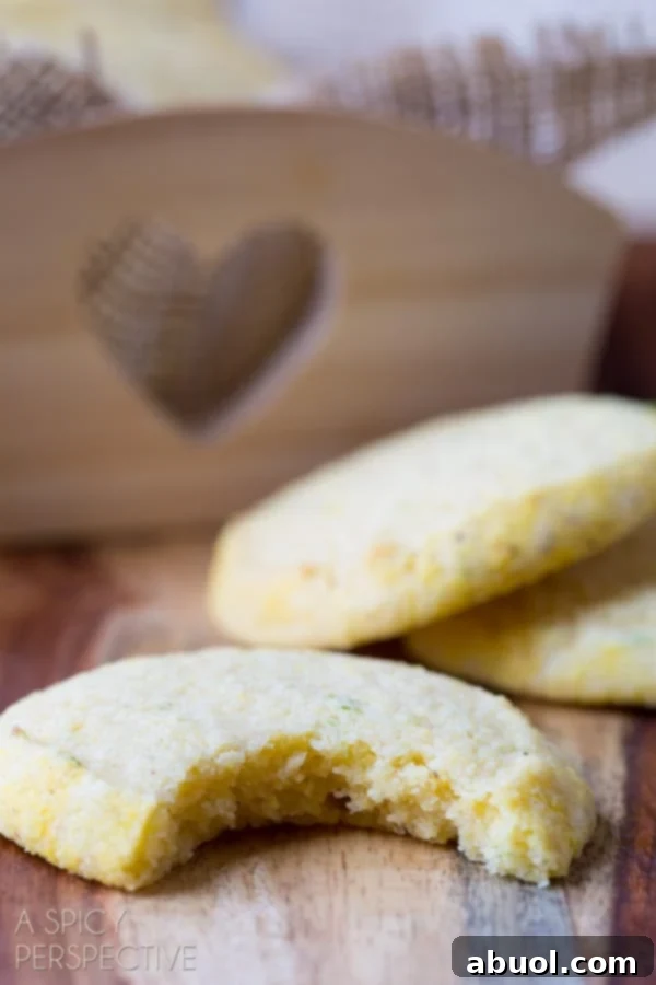 A close-up shot of a tender Cornmeal Sugar Cookie with a bite taken out, showing its perfect texture.