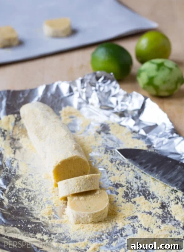 Cornmeal Sugar Cookie dough being precisely sliced from a chilled log.