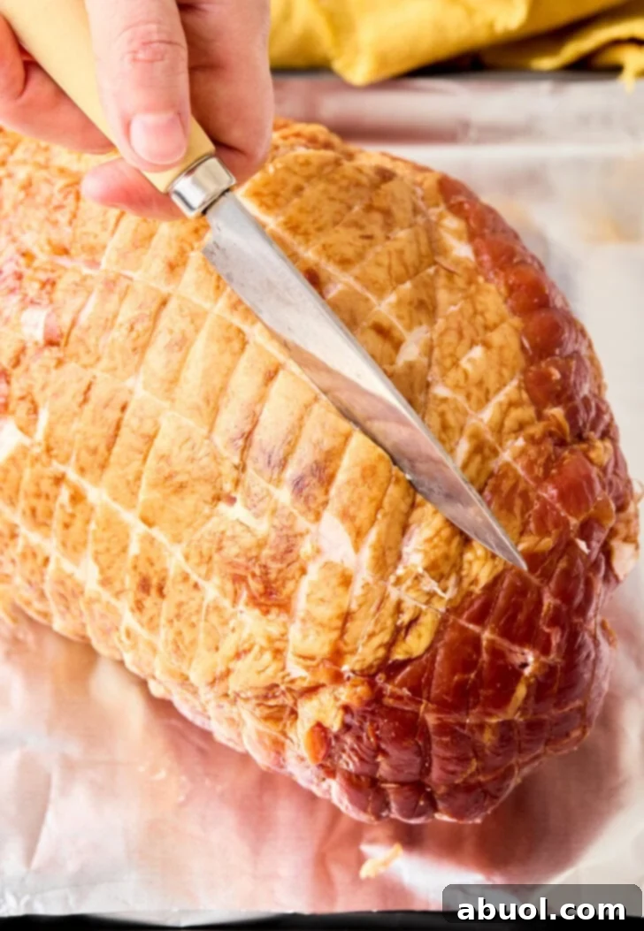 Step-by-step image: Carefully scoring the surface of the ham in a diamond pattern to allow the glaze to penetrate.