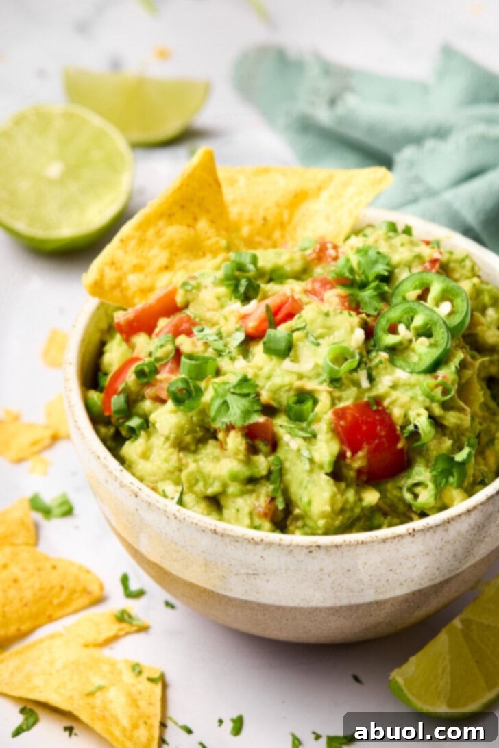 The Guacamole Gospel 9 Tortilla chips perfectly scooped into a bowl of creamy, fresh guacamole.