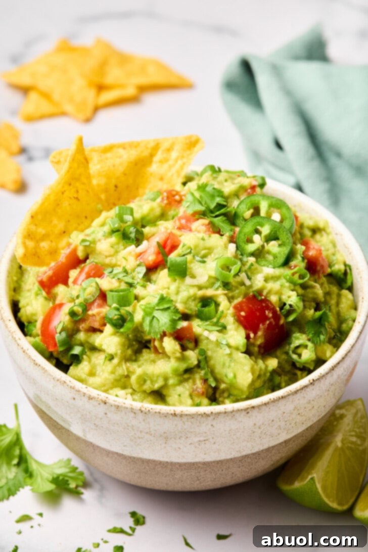 The Guacamole Gospel 11 Guacamole in a bowl served with a generous amount of tortilla chips, invitingly ready.