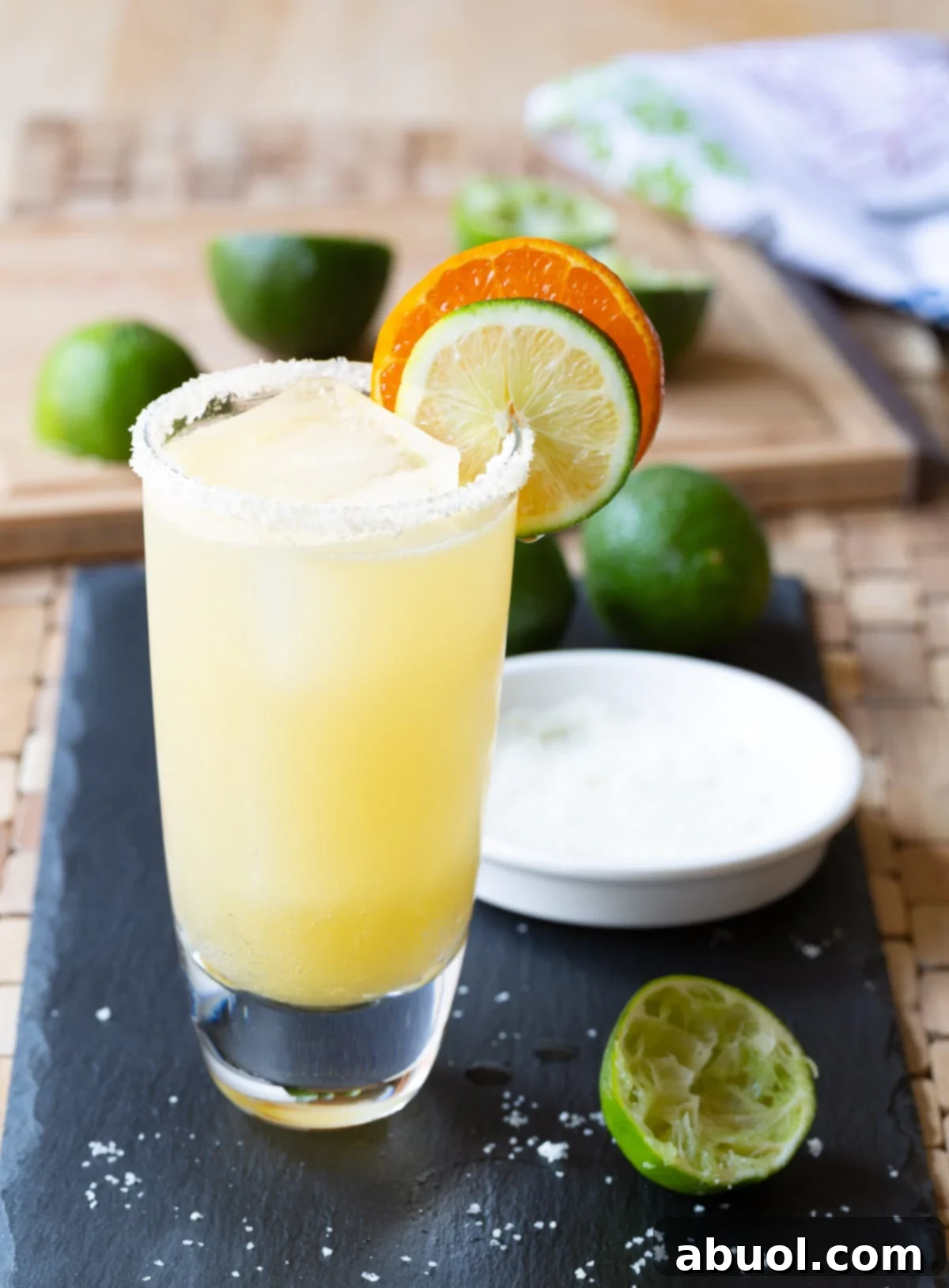 A refreshing margarita cocktail, perfectly garnished with a lime wedge and salt rim, presented in a stylish glass.