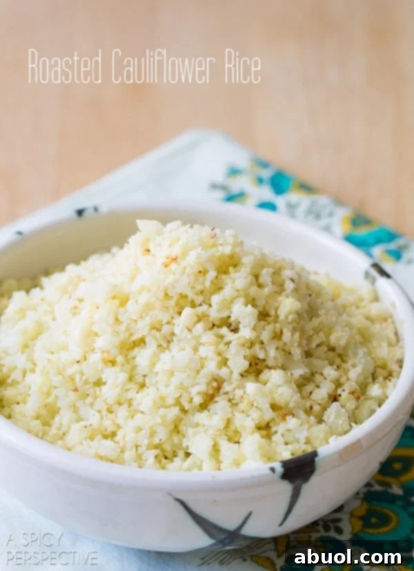 Roasted cauliflower rice in a decorative bowl, garnished with fresh herbs, ready to be served.