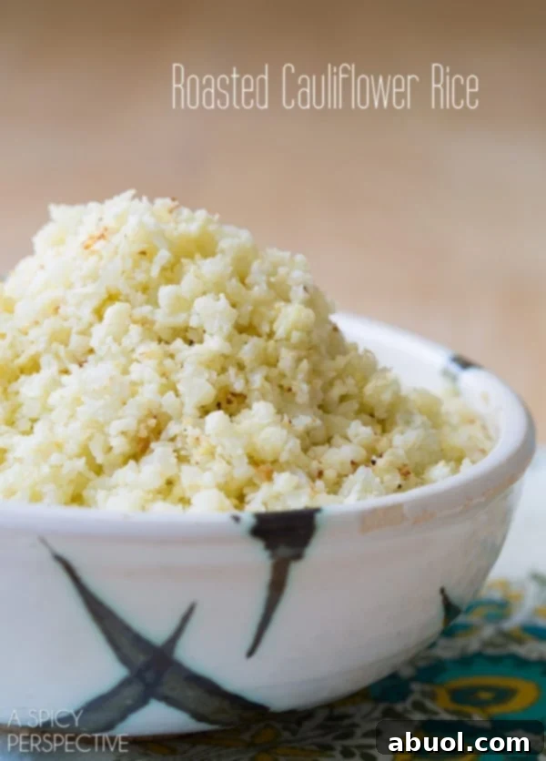Side view of roasted cauliflower rice piled high in a decorative bowl, garnished and ready to serve.