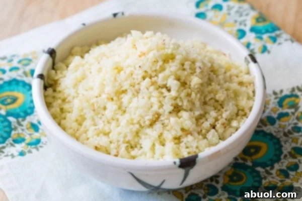 Close-up of fluffy Roasted Cauliflower Rice in a decorative bowl, showcasing its delicate texture.