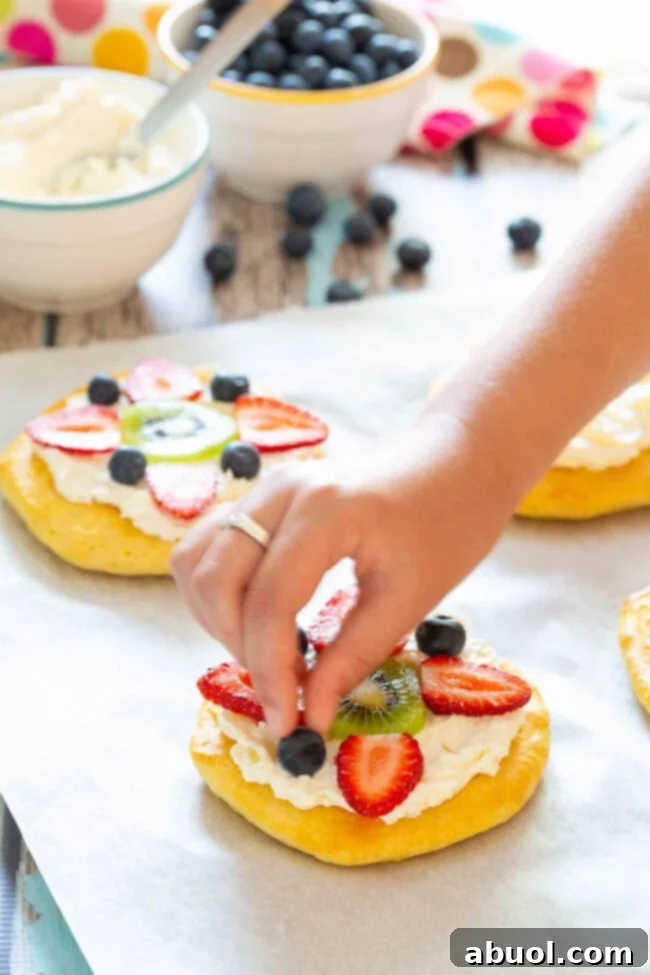 Easy Fruit Pizza for Breakfast - adding colorful fresh fruit to the cream cheese topping.