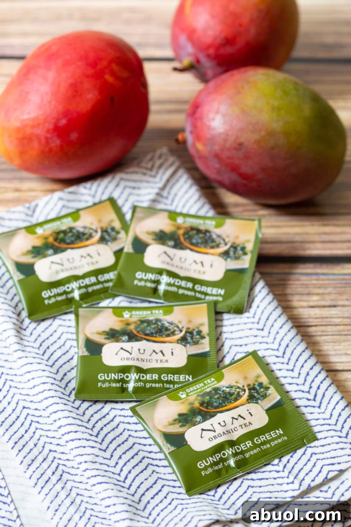 Green tea bags laid out on a clean white and blue towel, highlighting a key ingredient for a healthy energy-boosting smoothie.