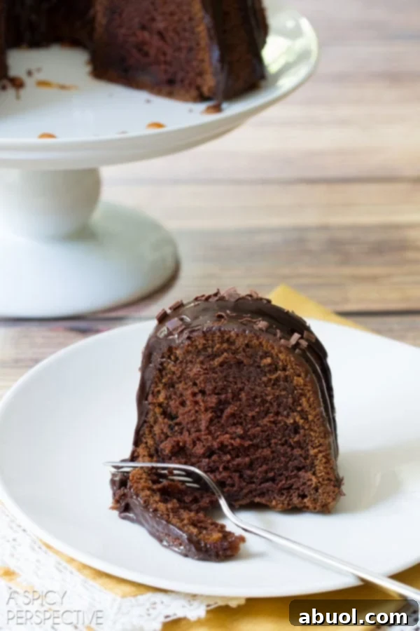 Boozy Baileys Bundt Bliss 11 Bundt cake on a plate with a fork poised, having taken a piece out of it.