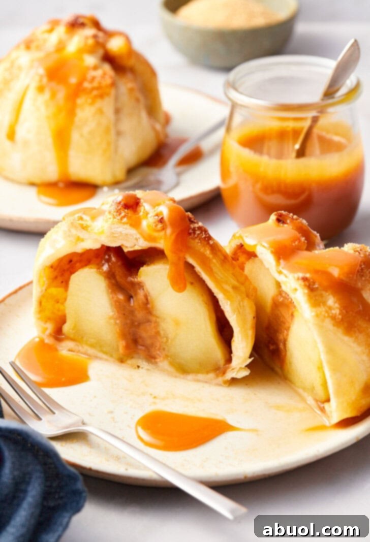 Simple baked apples in puff pastry on a plate, cut in half.