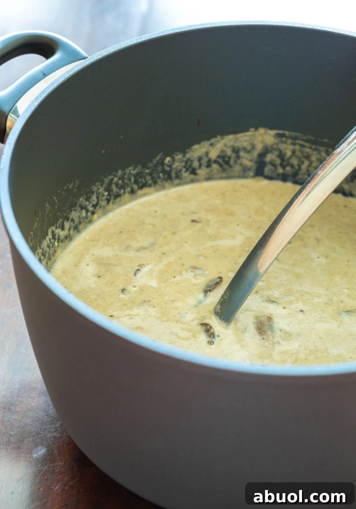 Earthy Forest Mushroom Elixir 4 Mushroom Soup - creamy soup base in large pot with ladle.