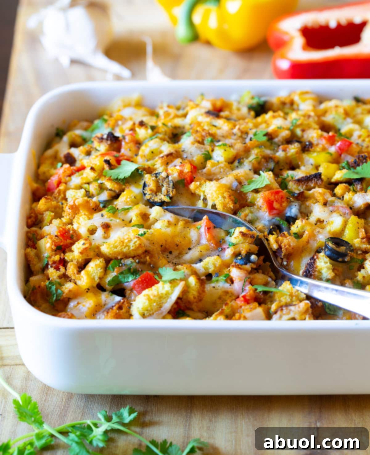 Cornbread Stuffing Recipe - Mexican Thanksgiving Recipe with chiles and cheese in baking dish with serving spoon