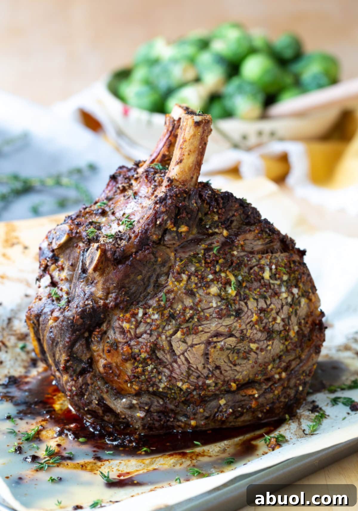 Close-up view of the perfectly crispy crust on the standing rib roast, sitting in a pan with its savory au jus.