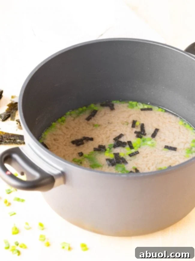 A full pot of freshly made Japanese Miso Soup, steaming gently, with tofu and green onions visible, ready to be served.