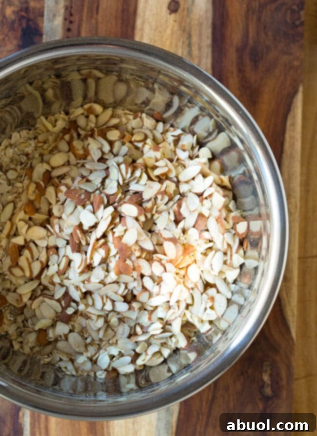Granola and nuts in a mixing bowl, ready to be combined for homemade granola bars.