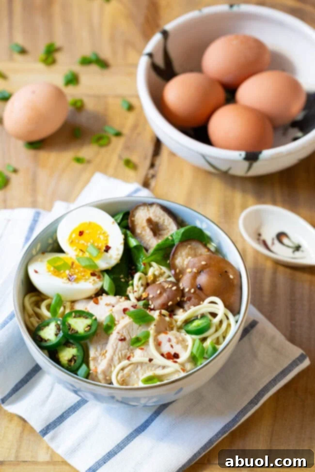 A perfectly garnished bowl of homemade ramen with chicken, egg, mushrooms, and greens, ready to be enjoyed.
