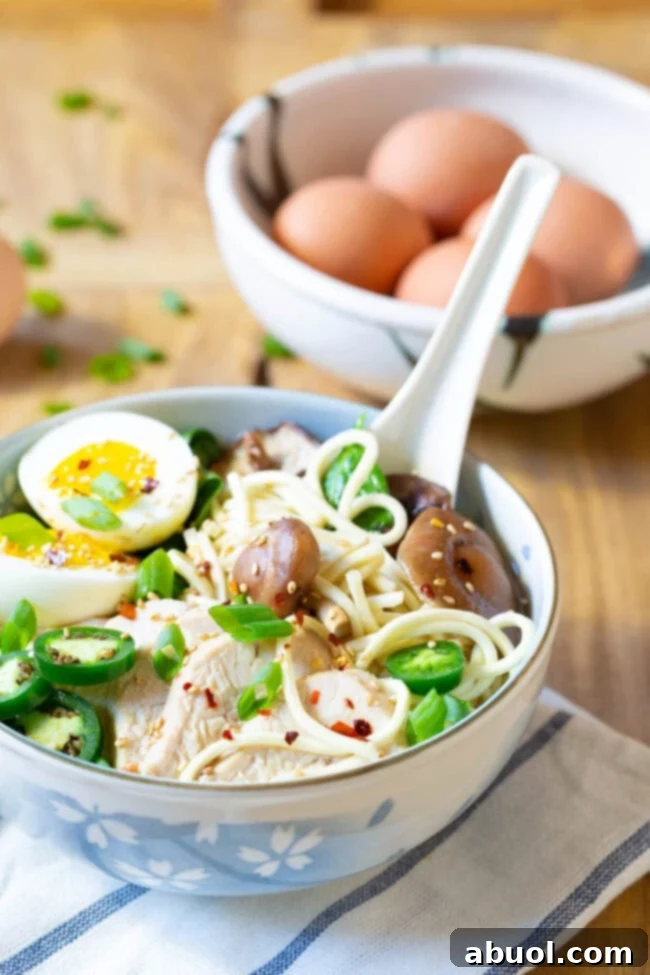A close-up of a bowl of fancy ramen, highlighting the rich broth and toppings, made easily in the Crock Pot.