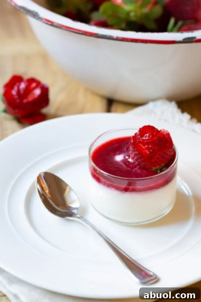 Small glass dish with silky Swedish Kreme topped with bright berry compote and a delicate strawberry rose.
