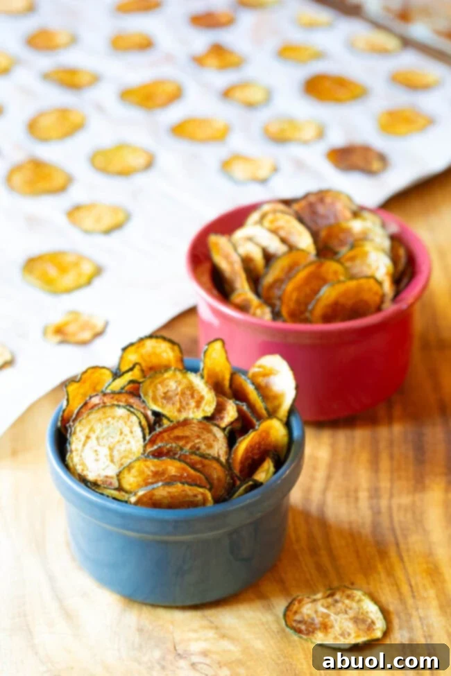 Two small ramekins filled with homemade baked zucchini chips, ready to be enjoyed.