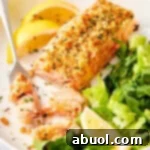 View of oven baked salmon with breadcrumb crust with some fish flaked off.