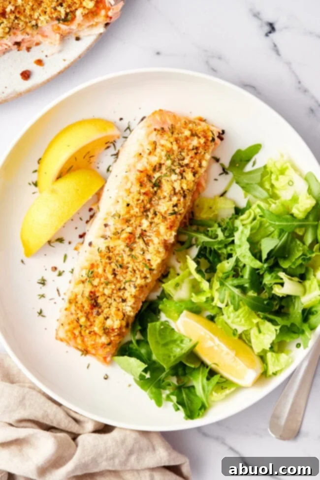 Freshly baked parmesan crusted salmon on a baking sheet, ready to be served, with a spatula alongside.