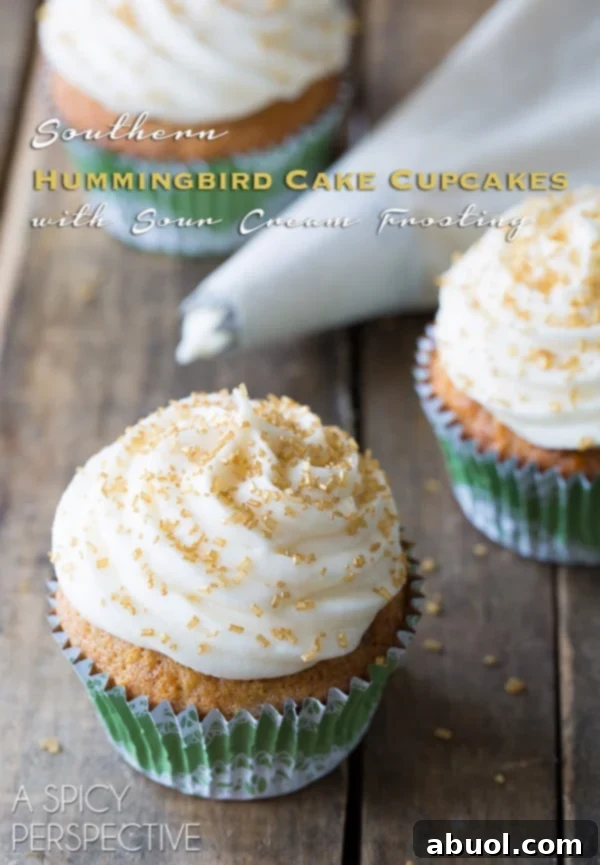 Hummingbird Cake Recipe made into cupcakes, topped with creamy frosting and a sprinkle of nuts.