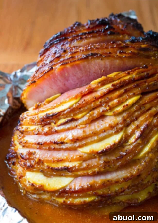 Spiral cut ham with apples sliced in between the slices with a glaze on top.