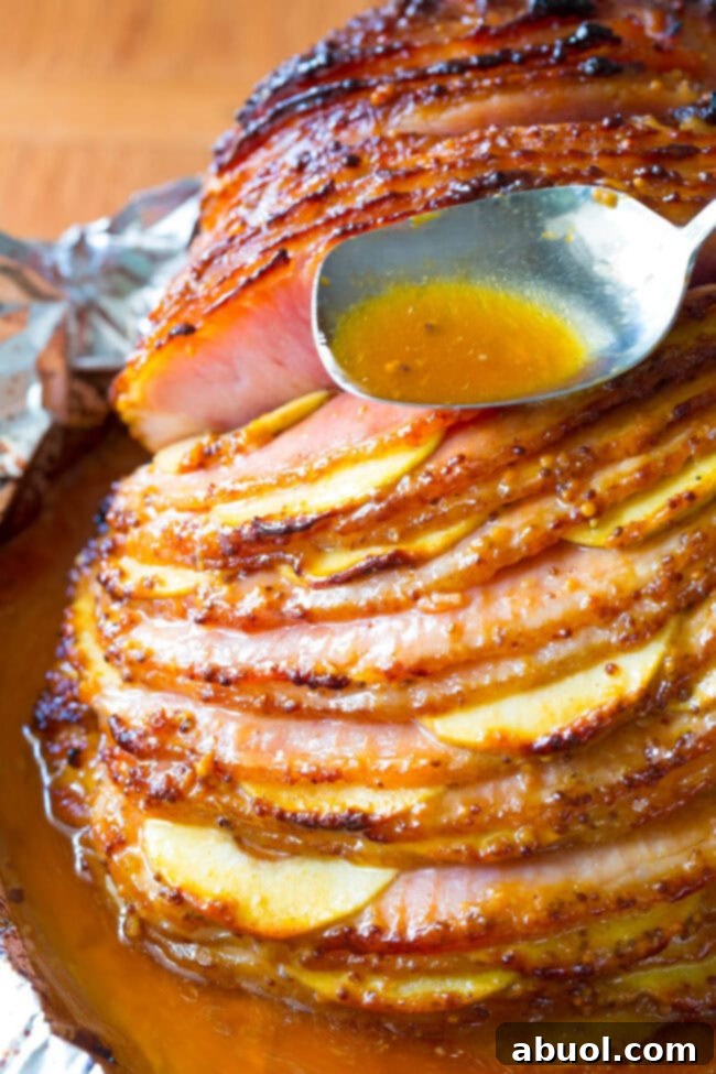 Side view of a glazed ham with apples