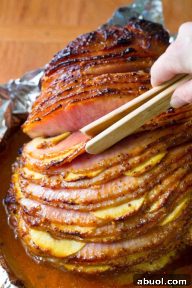 Choosing the slices of ham with the apples with a pair of tongs.