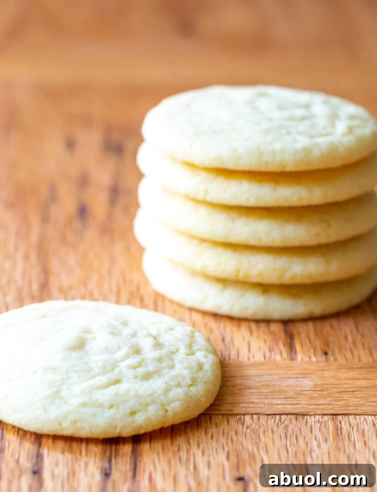 A side view of a stack of the world's best soft and chewy sugar cookies, glistening with sugar.