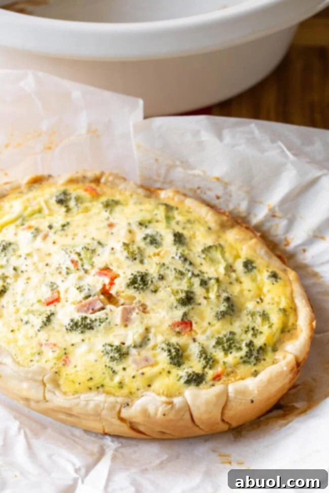 Top view of this breakfast egg dish full of vegetables on a piece of parchment paper.