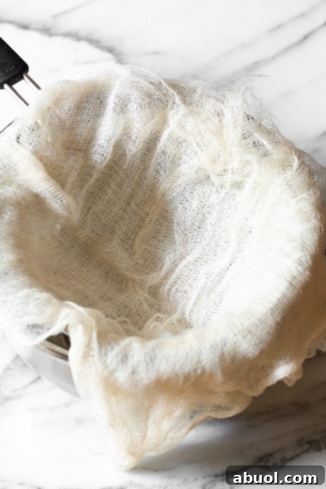 Crafting Creamy Ricotta from Scratch 8 Cheesecloth laid over a metal bowl.
