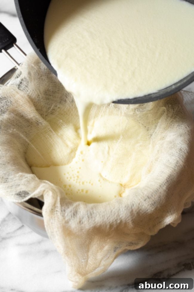 Crafting Creamy Ricotta from Scratch 9 Pouring curdled milk mixture over cheesecloth set in a sieve.