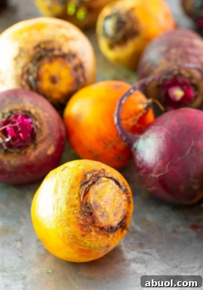 A selection of red and golden beets, fresh from the garden, artfully arranged on a rustic metal surface, highlighting their natural beauty and versatility.