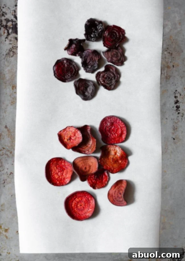 A comparative image showcasing two batches of baked beet chips; the top batch appears softer and less vibrant (made without the sweating technique), while the lower batch is perfectly crisp and colorful (made with the sweating technique), clearly demonstrating the superior result.
