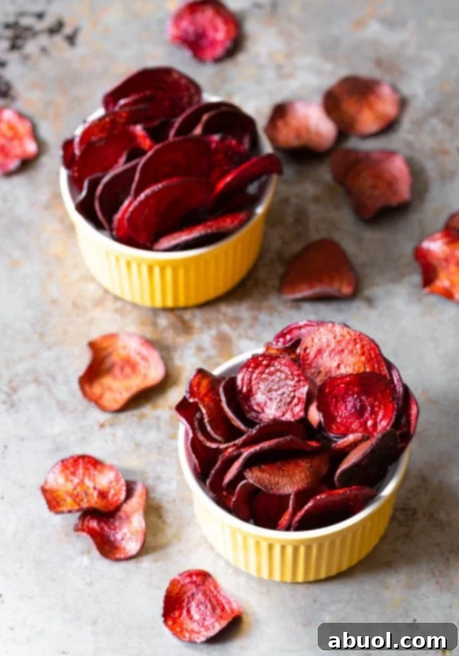 Delicious, golden-crisp baked beet chips arranged attractively in small yellow serving bowls, ready to be enjoyed as a healthy and colorful snack.